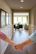 Couple holding his hands and walking through hallway of a new house