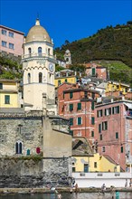 The church of Santa Margherita di Antiochia and nested houses built into the hillside with pastel-coloured facades