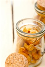 Cashew nuts on a glass jar over white rustic wood table