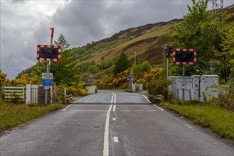 Scottish country road with Railroad Crossing in the highlands