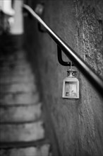 A small lantern hangs on the railing of a staircase