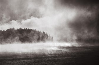 Sun penetrates through the morning mist at Lake Wolfgang