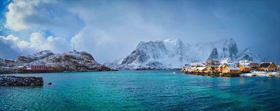 Panorama of yellow rorbu houses of Sakrisoy fishing village with snow in winter. Lofoten islands
