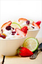 Fruit and yogurt salad healthy breakfast over white wood table