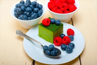 Green tea matcha mousse cake with raspberries and blueberries on top