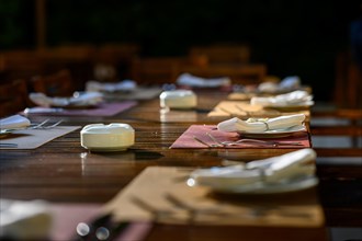Wooden table with cloth napkins in the garden of a restaurant