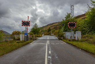 Scottish country road with Railroad Crossing in the highlands