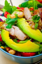 Fresh and healthy Chicken Avocado salad over rustic wood table