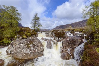 Waterfall on river Coupal and mountain range Buachaille Etive Mor