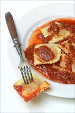 Ravioli with tomato sauce on plate with fork