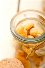 Cashew nuts on a glass jar over white rustic wood table