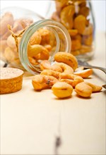 Cashew nuts on a glass jar over white rustic wood table
