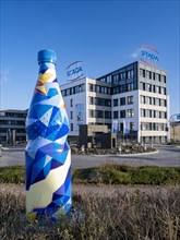 Building of the pharmaceutical company Stada Arzneimittel AG behind an oversized mineral water bottle