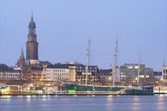 Landungsbruecken Hamburg at blue hour with museum and monument ship Rickmer Rickmers and main church St. Michaelis