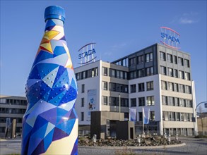 Oversized mineral water bottle in front of the building of the pharmaceutical company Stada Arzneimittel AG