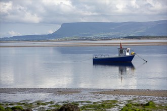Boat in shallow water with scenic Irish view of Ben Bulben in background. County Sligo