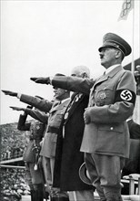 Adolf Hitler salutes the Olympic flag