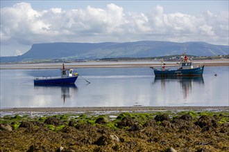 Boat in shallow water with scenic Irish view of Ben Bulben in background. County Sligo