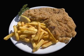 Wiener Schnitzel with french fries on a black background