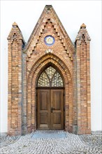 Portal at St. John's Church with the symbol of the Trinity