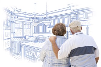 Curious senior couple looking over blue custom kitchen design drawing