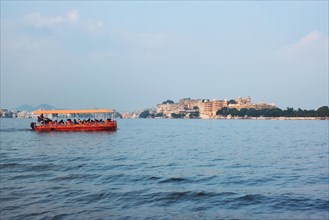 Toruist boat in Lake Pichola with City Palace in background. Udaipur