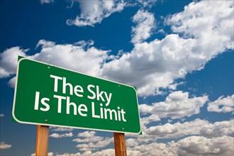The sky is the limit green road sign with dramatic clouds and sky