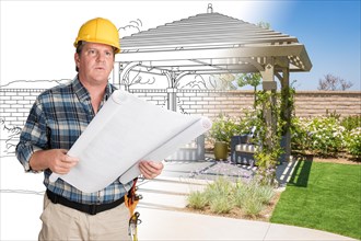 Male contractor with house plans wearing hard hat in front of custom pergola patio covering drawing photo combination