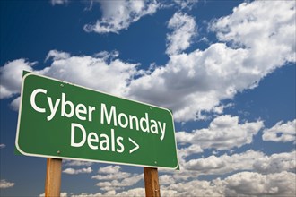 Cyber monday deals green road sign with dramatic clouds and sky
