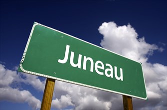 Juneau road sign with dramatic blue sky and clouds