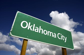 Oklahoma city road sign with dramatic blue sky and clouds