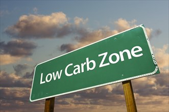 Low carb zone green road sign in front of dramatic clouds and sky