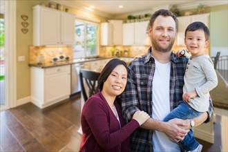 mixed-race chinese and caucasian parents and child indoors inside beautiful custom kitchen