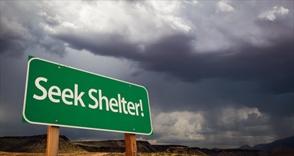 Seek shelter green road sign with dramatic clouds and rain