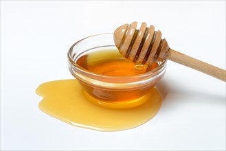 Bee honey with honey spoon in bowl
