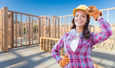Young attractive female construction worker wearing gloves