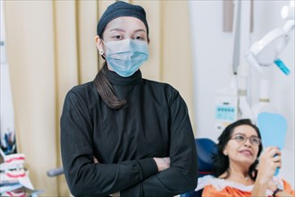 Dental doctor standing in clinic wearing mask