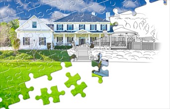 Puzzle pieces fitting together revealing finished house build over drawing