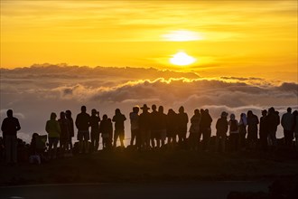 Touristen beobachten den Sonnenuntergang auf dem Gipfel des Haleakala Vulkan