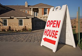 Open house sign in front of A brand new home. room for your own message at the top of the sign