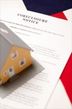 Foreclosure notice and house on the american flag with selective focus