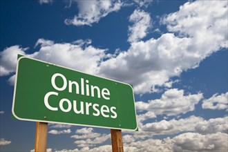 Online courses green road sign with dramatic sky and clouds
