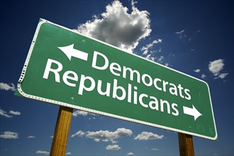 Democrats and republicans green road sign over dramatic blue sky and clouds with clipping path