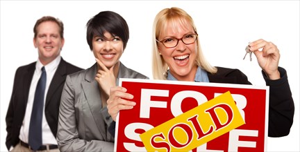 Real estate team behind with blonde woman in front holding keys and sold for sale real estate sign isolated on a white background