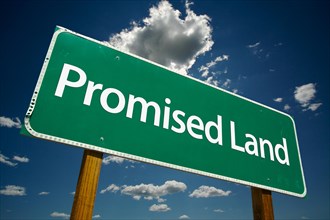 Promised land green road sign with dramatic clouds and sky