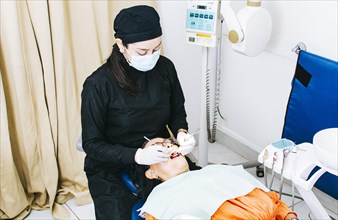 Woman dentist with patient lying down
