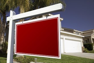 Blank real estate sign in front of house