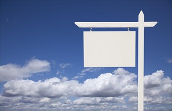 Blank white real estate sign over clouds and sky ready for your own message
