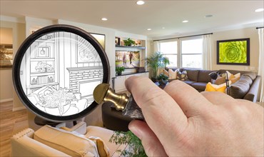 Hand holding magnifying glass revealing custom living room design drawing and photo combination