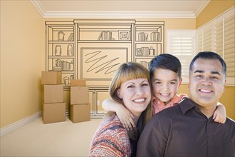 Happy young mixed-race family in room with moving boxes and drawing of entertainment unit on wall